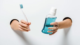 Mãos a segurar colutório ou elixir bucal